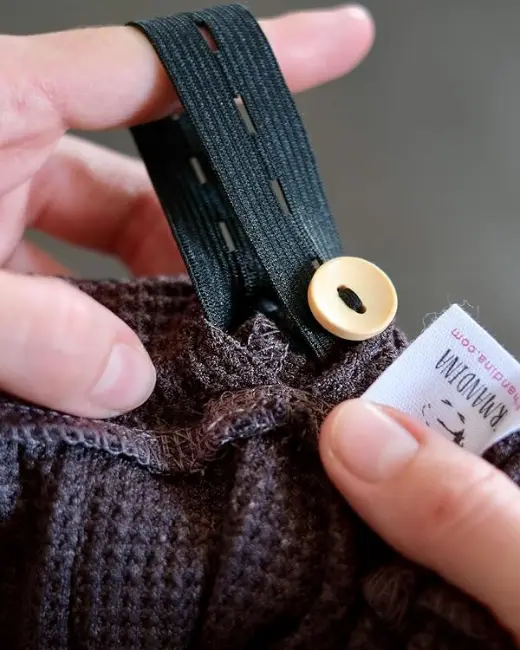 The elastic band with buttonholes and a wooden button inside the hat